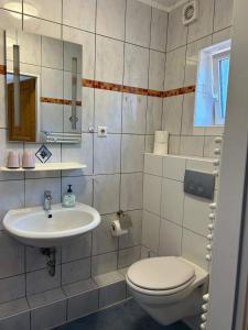a bathroom with a toilet and a sink at Pension Deichblick 1 in Norden