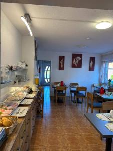 a large kitchen with tables and chairs in a room at Pension Deichblick 1 in Norden
