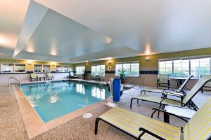 una piscina en un hotel con bancos y mesas en Hampton Inn Ellsworth, en Ellsworth