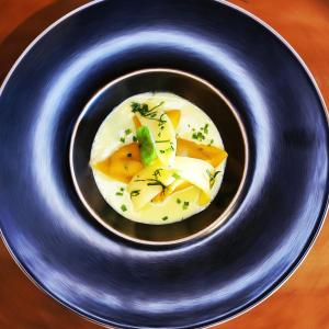 a blue plate with a bowl of food on a table at Auberge le Mont-Gelé in Iserables