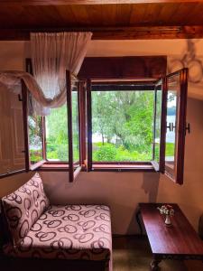 ein Wohnzimmer mit einer Couch und zwei Fenstern in der Unterkunft Varljivo leto, Fruska gora in Čortanovci + 12 Fotos