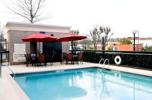a swimming pool with chairs and umbrellas next to a building at Hampton Inn & Suites Birmingham-Pelham - I-65 in Pelham