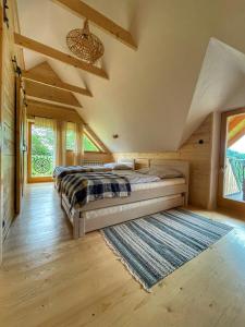 a bedroom with a bed and a rug at Gliniana Chata in Zawoja