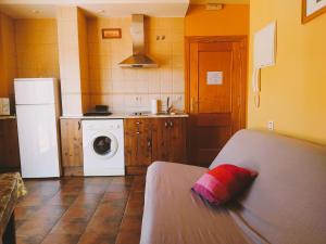 a kitchen with a refrigerator and a washing machine at El Balcón de Cabezuela Valle del Jerte in Cabezuela del Valle