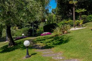 un giardino con una palla bianca su un palo nell'erba di Hotel Bellevue a Gardone Riviera