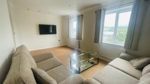 a living room with a couch and a glass table at Hana Holiday Home - 4 En-suite Bedroom house in Menai Bridge