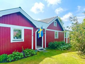 a red house with a flag on it at 7 person holiday home in KöPINGSVIK-By Traum in Köpingsvik