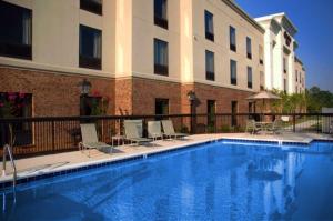 a hotel swimming pool with chairs and a building at Hampton Inn Jasper in Jasper