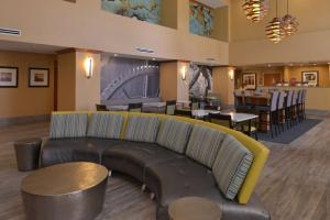 a lobby with a couch and tables and a restaurant at Hampton Inn and Suites Bakersfield North-Airport in Bakersfield