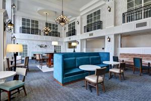 a lobby with a blue couch and tables and chairs at Hampton Inn & Suites Birmingham-Hoover-Galleria in Hoover