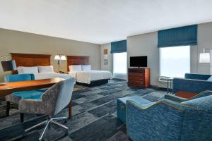 ein Hotelzimmer mit 2 Betten, einem Schreibtisch und Stühlen in der Unterkunft Hampton Inn & Suites Birmingham-Hoover-Galleria in Hoover