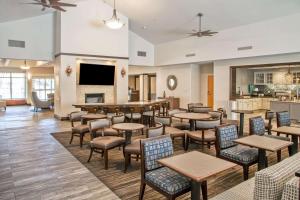 a restaurant with tables and chairs and a fireplace at Homewood Suites Bakersfield in Bakersfield