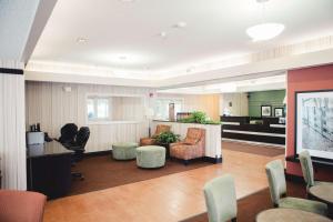 a lobby with chairs and a counter in a room at Hampton Inn Bloomington West in Bloomington