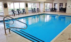 uma grande piscina com cadeiras e mesas em Hampton Inn Bloomington West em Bloomington