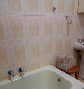 a bathroom with a bath tub and a sink at Tia's Place in Krugersdorp