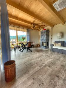 a living room with a table and a fireplace at Gliniana Chata in Zawoja
