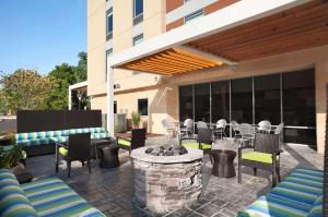 a patio with a fire pit and chairs and a building at Home2 Suites Nashville Airport in Nashville