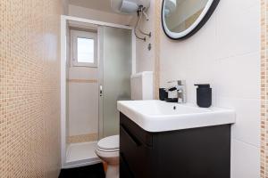 a bathroom with a sink and a toilet and a mirror at Apartman Milazzi in Baška