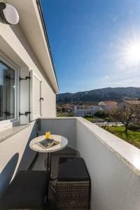 a table and chairs on a balcony with a view at Apartman Milazzi in Baška