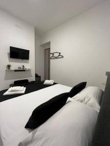 a bedroom with a large white bed with black pillows at El Puerto B&B in Vieste