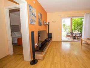 a living room with a television and a room with a table at BENCUN apartmani in Makarska +21 photos