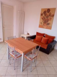 een woonkamer met een houten tafel en een bank bij BELLISSIMA! CASA BABY - in Massarosa