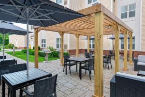 a patio with tables and chairs and an umbrella at Homewood Suites by Hilton Boston/Canton, MA in Canton