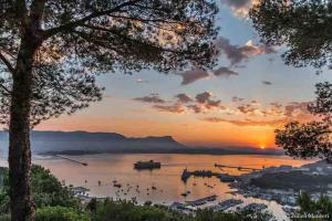 una puesta de sol sobre un lago con barcos en el agua en Le Zenith en Saint-Mandrier-sur-Mer