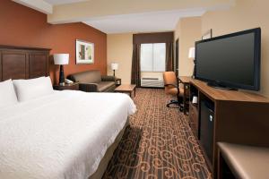 a hotel room with a bed and a flat screen tv at Hampton Inn Haverhill in Haverhill