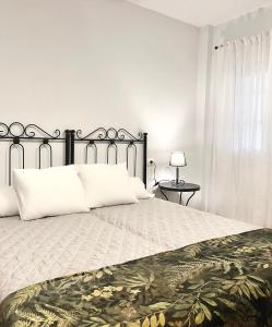 1 dormitorio blanco con 1 cama grande con almohadas blancas en El Balcón de Alange en Alange