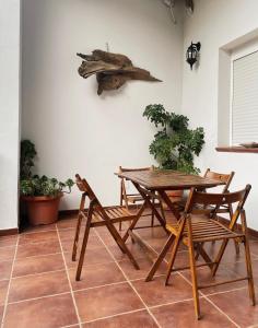 una mesa de madera y sillas con un pez en la pared en El Balcón de Alange en Alange