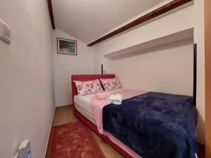 a small bedroom with a bed with pink and blue sheets at Leona in Novigrad Istria