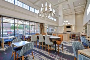 a dining room with tables and chairs and a chandelier at Homewood Suites Boston Peabody in Peabody