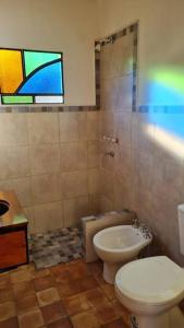 a bathroom with a toilet and a sink and a window at Hospedaje Sauce Linda - Casa Brea in Piedra Pintada +27 photos