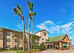 a hotel with palm trees and a gazebo at Homewood Suites by Hilton Brownsville in Brownsville