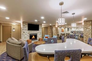 a lobby with chairs tables and a fireplace at Homewood Suites by Hilton Brownsville in Brownsville