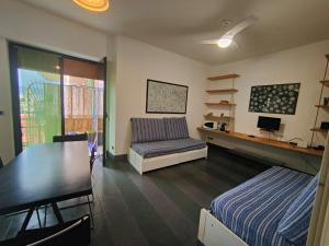 - une chambre avec un lit, une table et un canapé dans l'établissement Casa Mario, à Loano