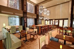 un restaurante con mesas, sillas y lámparas de araña en Hampton Inn & Suites Winnie, en Winnie