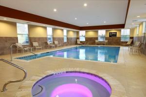 une grande piscine dans un hôtel avec un bain à remous dans l'établissement Hampton Inn & Suites Winnie, à Winnie