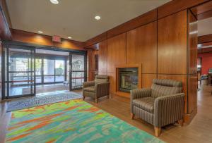 een lobby met 2 stoelen en een open haard bij Hampton Inn Batavia in Batavia