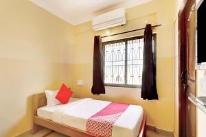 ein kleines Schlafzimmer mit einem Bett und einem Fenster in der Unterkunft OYO Flagship Sunder Nivas in Bangalore