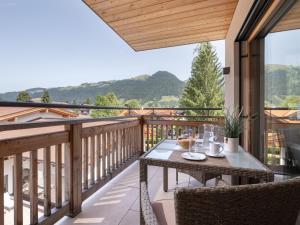 patio con mesa y sillas en el balcón en Herzi Chalet - top ausgestattet, neu, chic und sehr gemütlich, en Walchsee