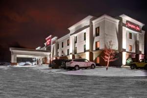 a hotel with cars parked in a parking lot at night at Hampton Inn Coldwater in Coldwater