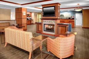 a living room with a fireplace and a tv at Hampton Inn Coldwater in Coldwater