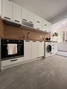 una cucina con armadi bianchi e una lavatrice/asciugatrice di Céntrico ~ Modern 1BD Flat in Varna a Varna