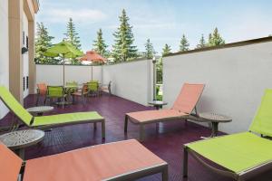 eine Terrasse mit bunten Stühlen, Tischen und Stühlen in der Unterkunft Hampton Inn Buffalo-Airport Galleria Mall in Cheektowaga