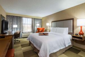 a hotel room with a bed and a flat screen tv at Hampton Inn Buffalo-Airport Galleria Mall in Cheektowaga