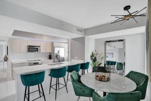 a kitchen and dining room with a table and chairs at Gorgeous 4 BDRM Condo Stunning Views Beach Access in Hallandale Beach