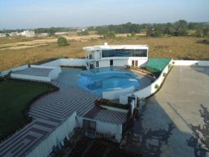 a large building with a swimming pool in front of it at Pipul Utkal Continental in Jhārsuguda