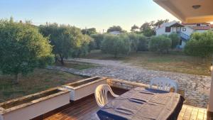 a patio with a table and chairs on a balcony at Apartman Lana in Vir